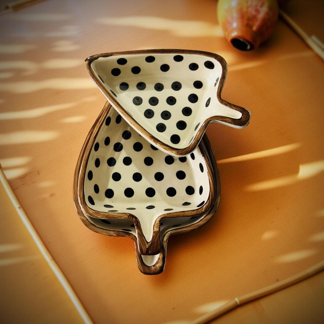 Decorative ceramic dish with black polka dots on a wooden surface