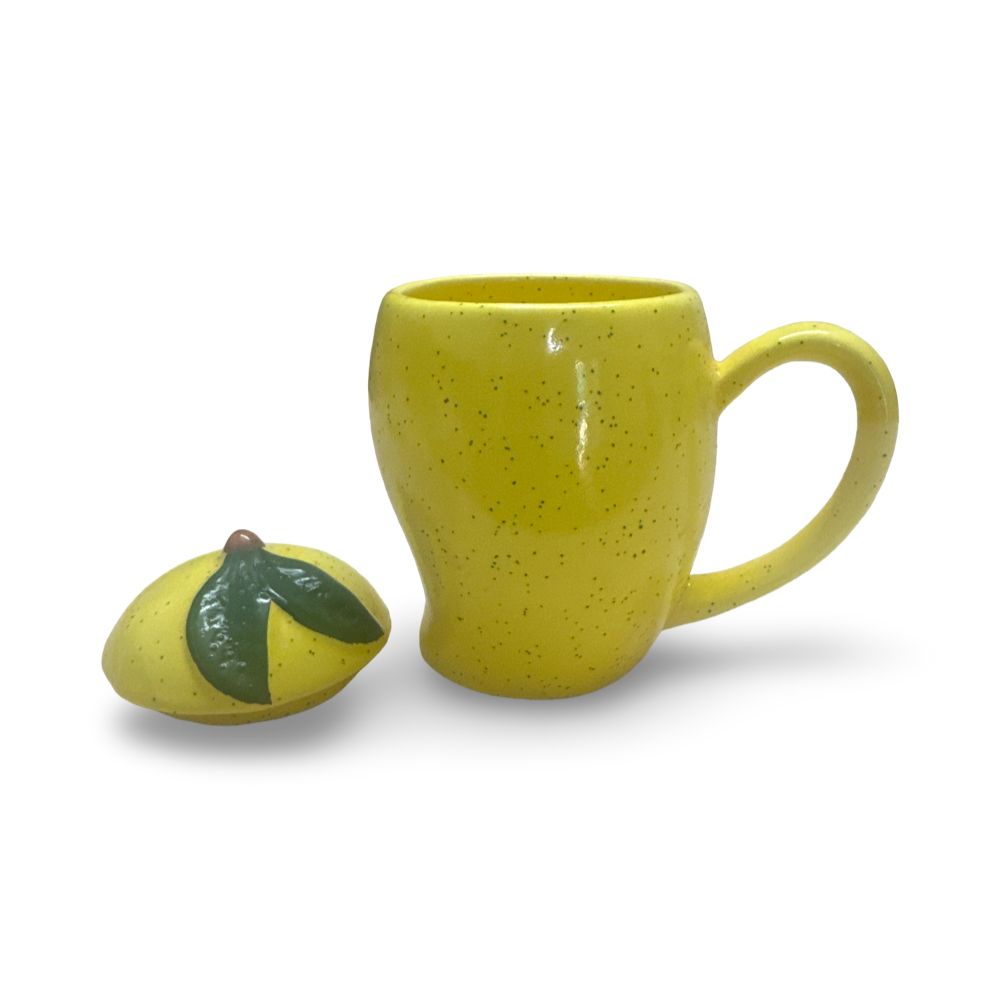 Tropical mango ceramic tea mug with handle and matching lid beside sliced mangoes in a bright modern home setting