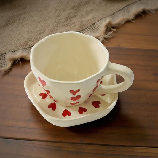 Ceramic cup with red heart patterns on a wooden surface