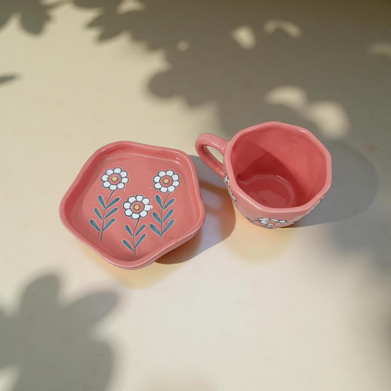 Aesthetic handcrafted pink daisy mug placed on a neutral table surface