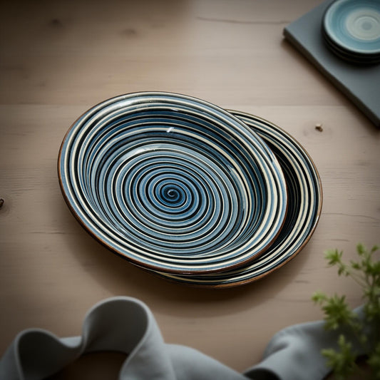 Set of two blue spiral ceramic bowls styled on soft fabric with kitchen decor elements