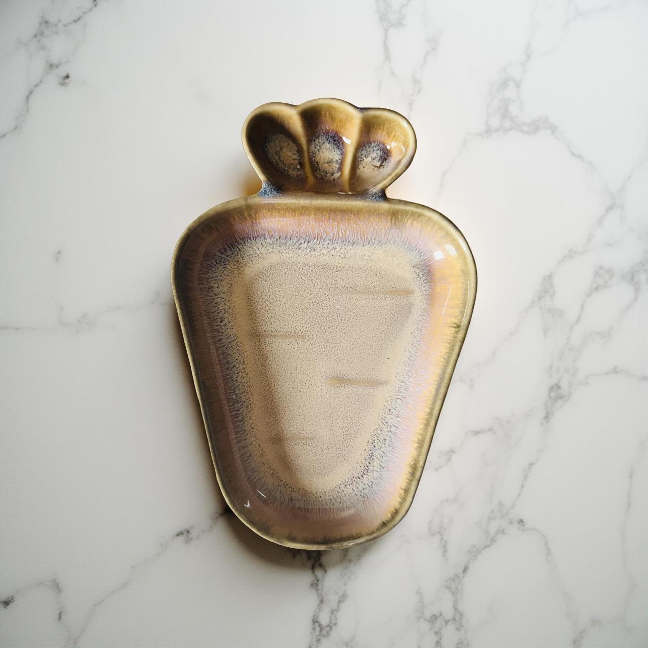 Ceramic dish with shell design on a marble surface