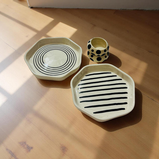 2 geomatric shaped plates with polka dots dip bowl placed on wooden surface.