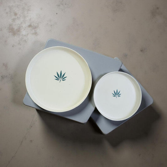 Two white plates with cannabis leaf symbols on a gray surface