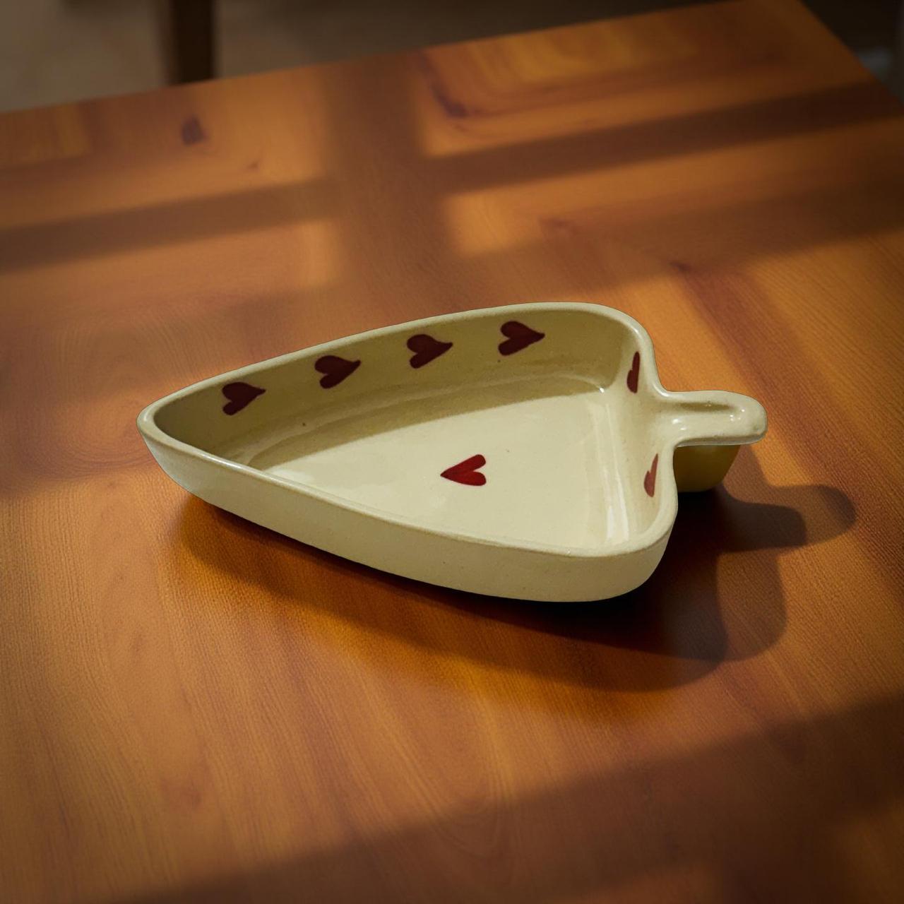 ceramic heart bowl kept on wooden surface.