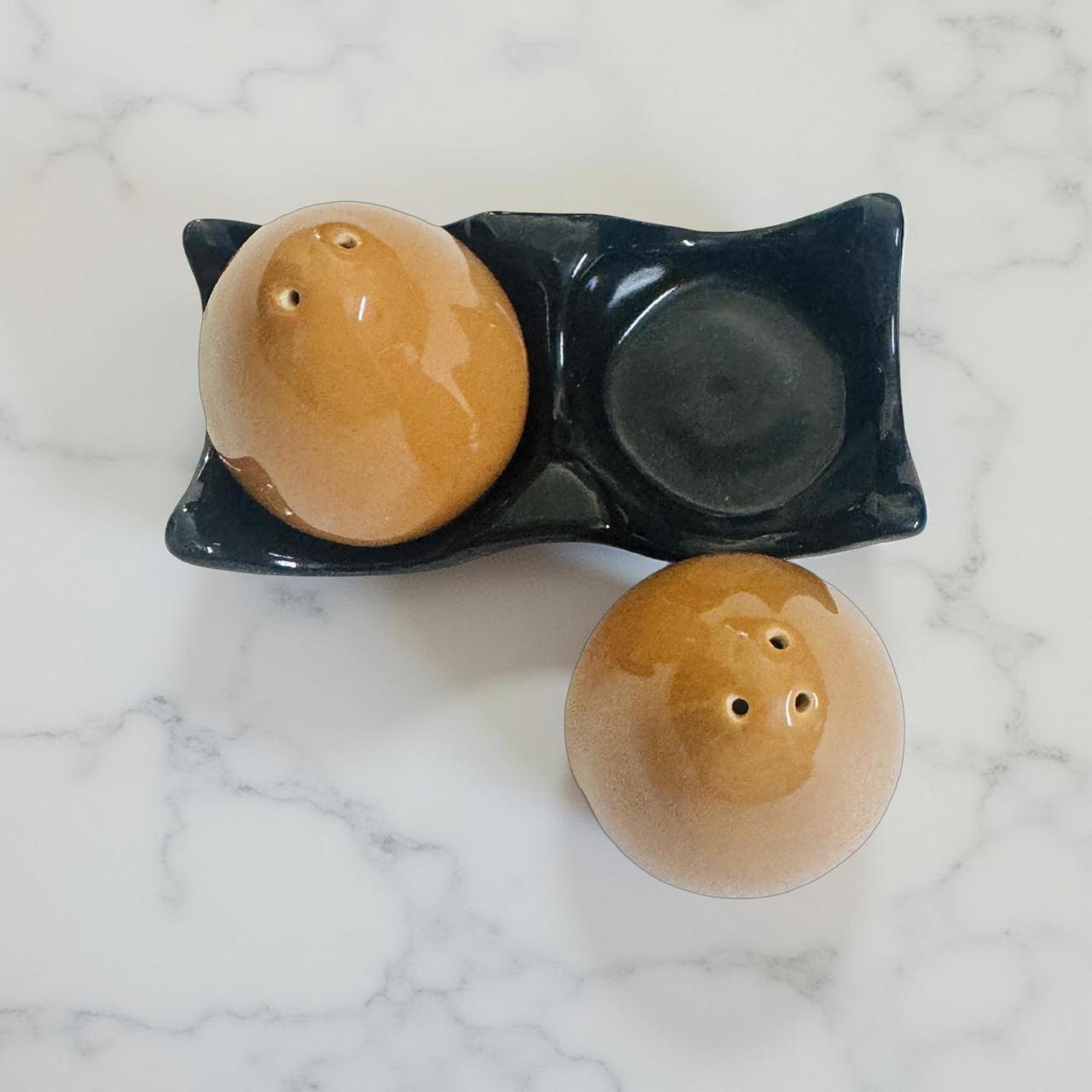 Pair of ceramic salt and pepper shakers on a marble surface
