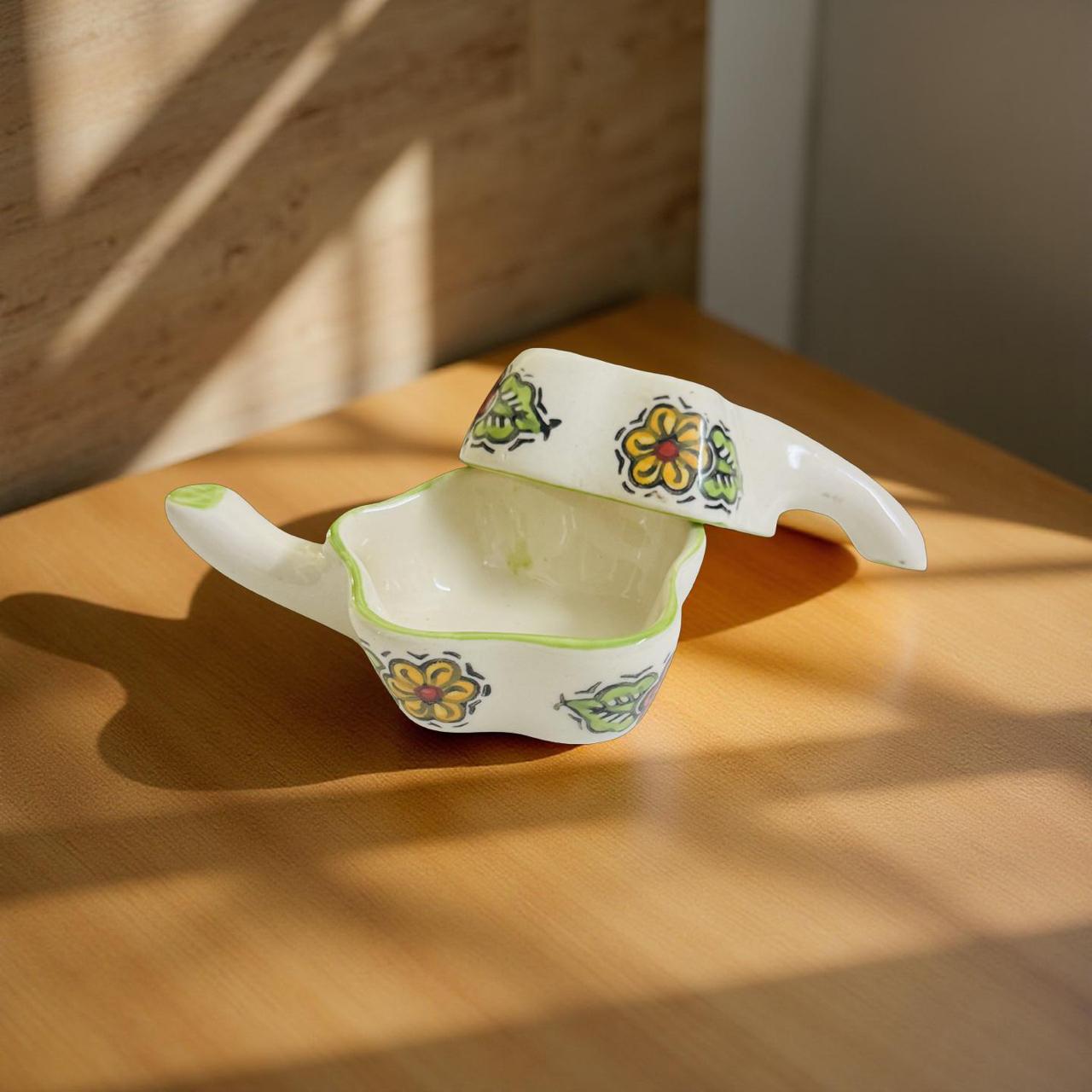 Ceramic container with floral designs on a wooden surface
