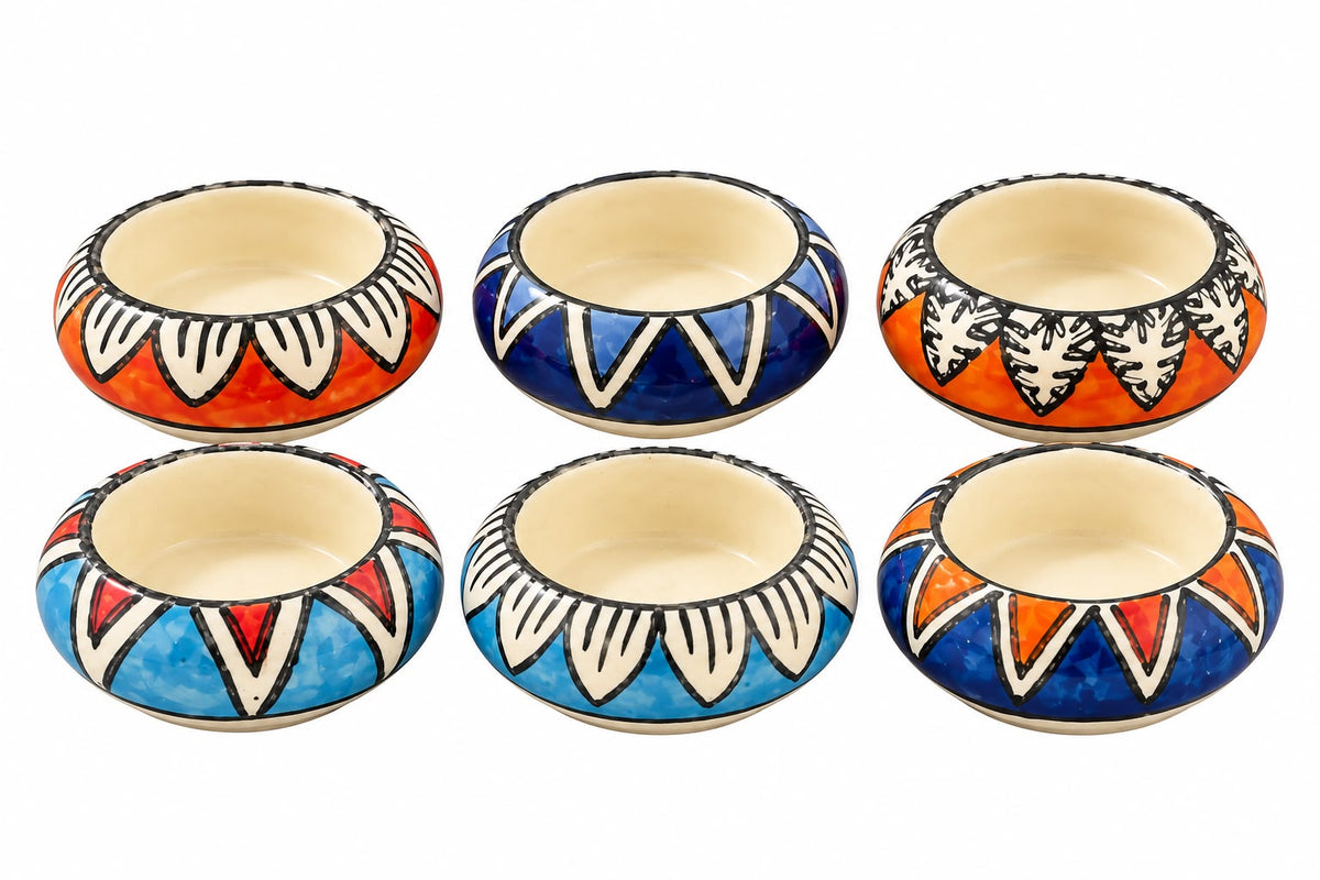 Six small hand-painted ceramic bowls arranged in two rows of three on a white background. Each bowl has a different color combination of orange, blue, and light blue, with black hand-drawn geometric patterns and cream-colored interiors.