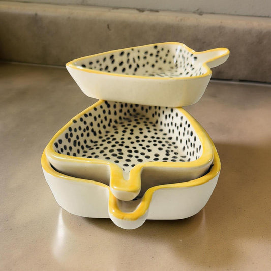 Two-tiered ceramic bowl with spotted design on a neutral background