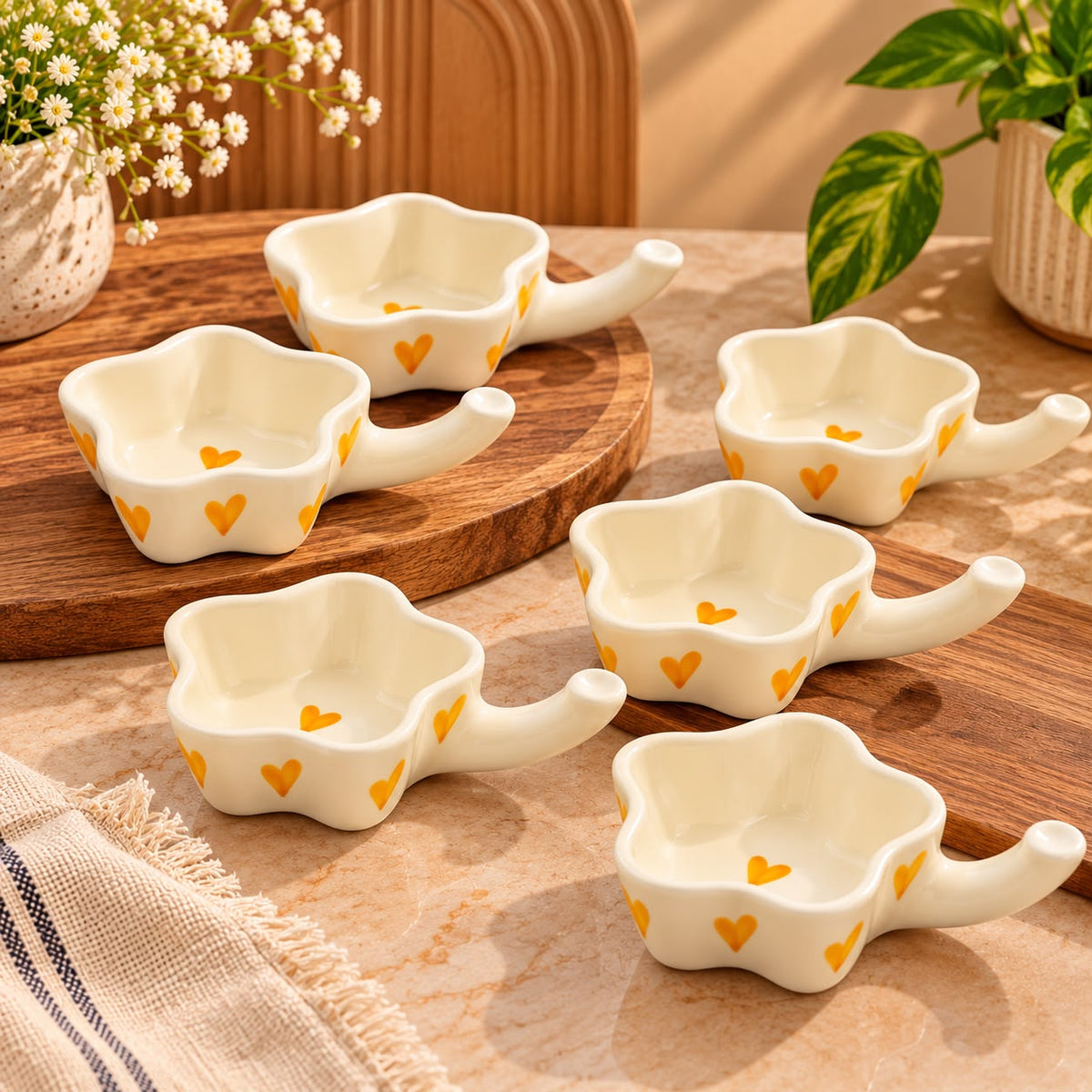 Yellow heart patterned ceramic dishes arranged with Indian meal accompaniments and savoury snacks