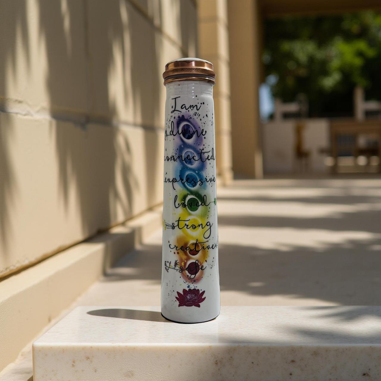 Tumbler with motivational quote and colorful design on a stone surface outdoors