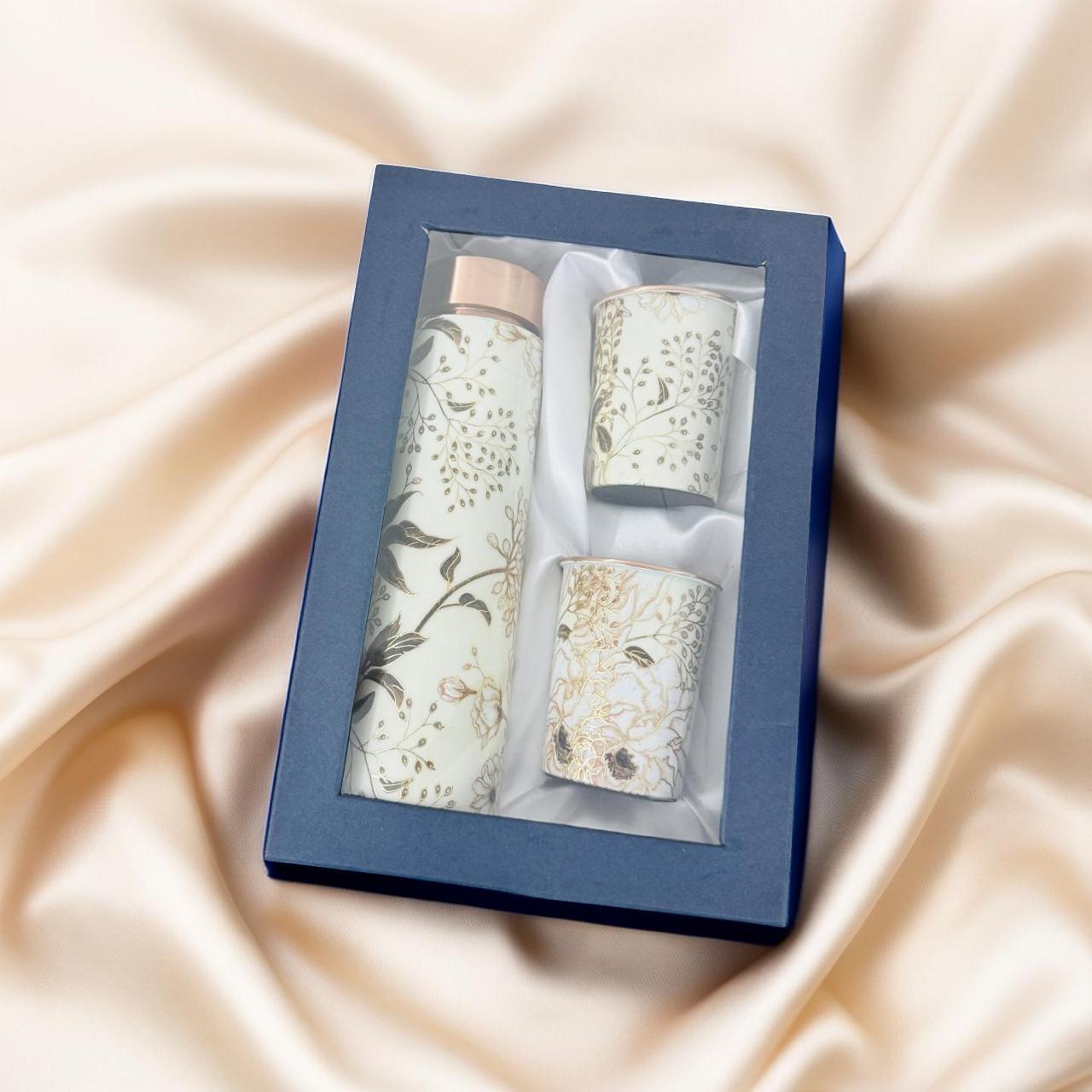 Set of three cylindrical containers with floral patterns in a blue box on a beige fabric background