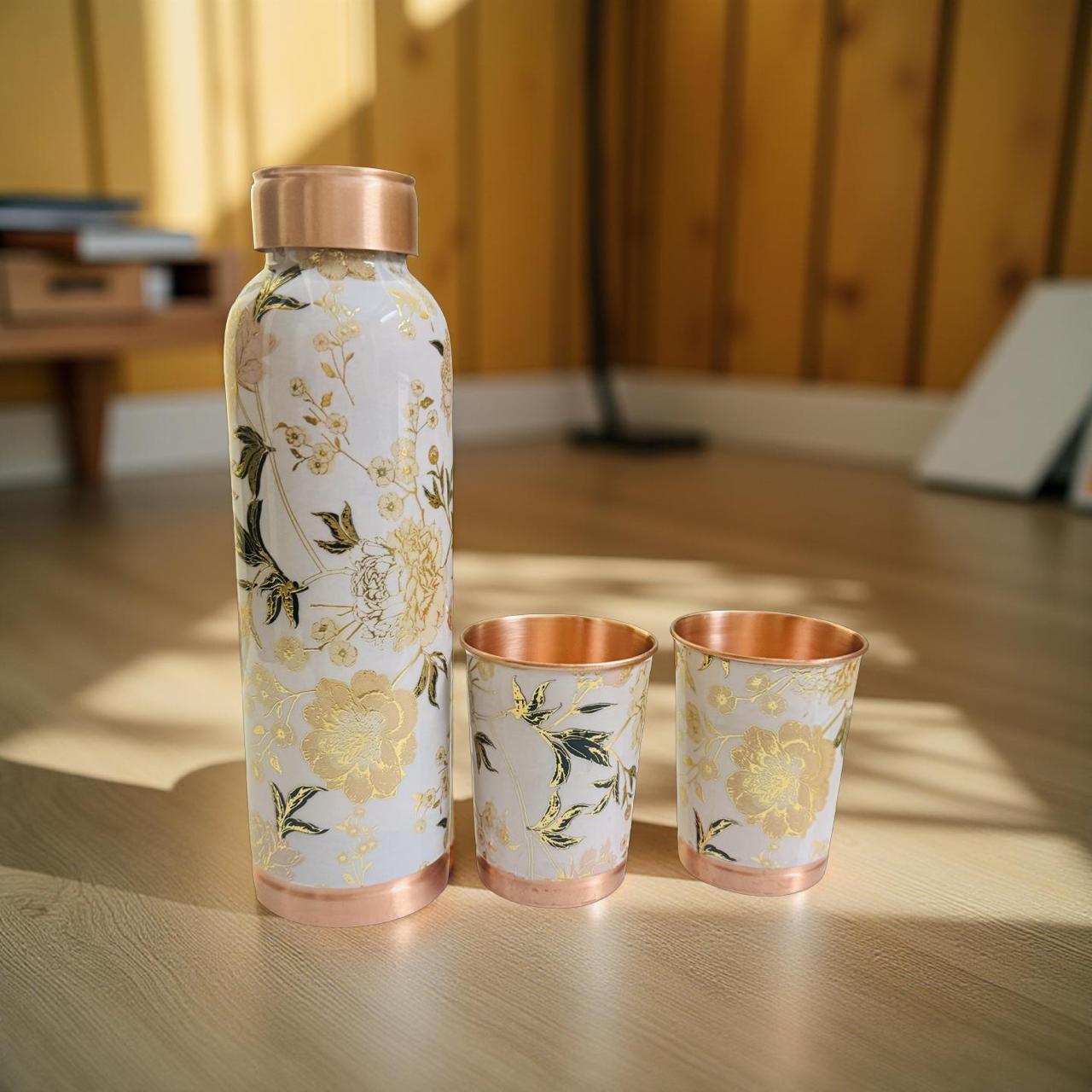 Floral-patterned bottle and cups on a wooden surface