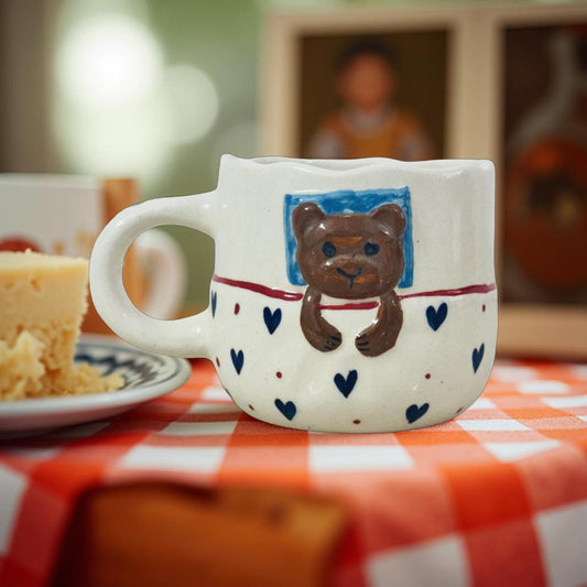 cute sleeping bear mug kept on a coffee table with dry cakes and cookies
