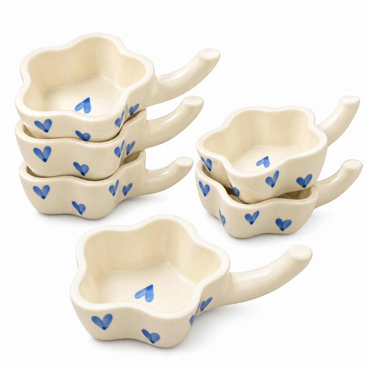 Ceramic sweet serving bowls with blue heart detailing arranged on a wooden dessert table