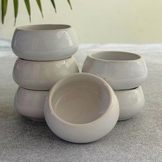 Set of white ceramic bowls on a light surface with a blurred background