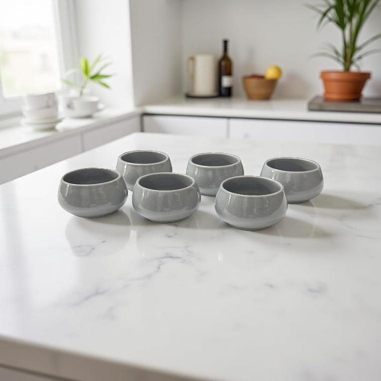 Set of six mist grey ceramic chutney bowls on a marble kitchen counter, styled in a serene, minimal kitchen.
