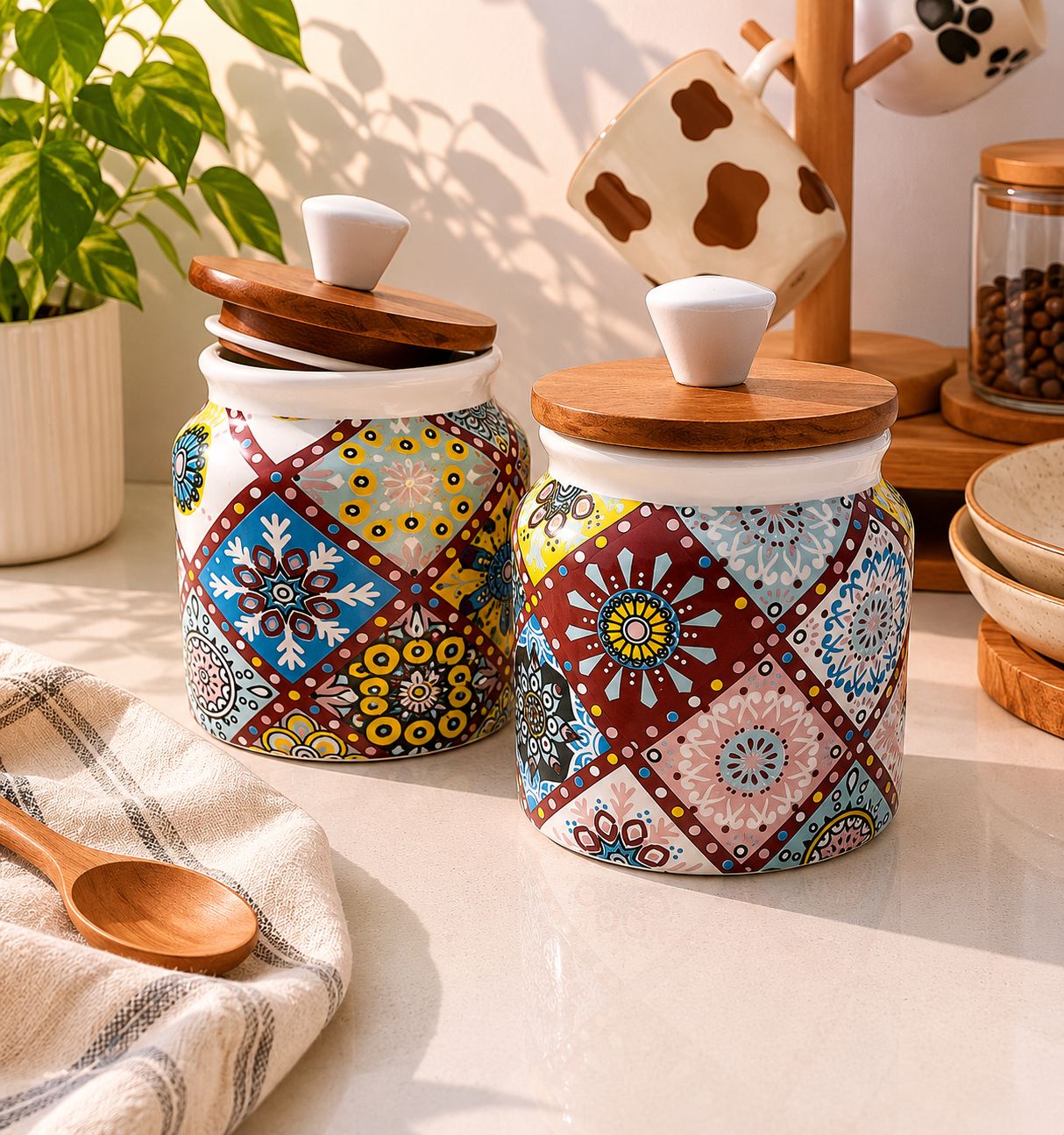 Two ceramic jars with colorful patterns and wooden lids on a kitchen counter.
