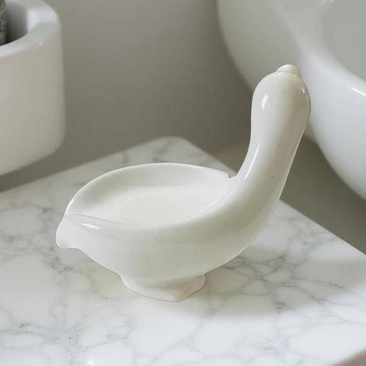 White ceramic duck-shaped object on a marble surface