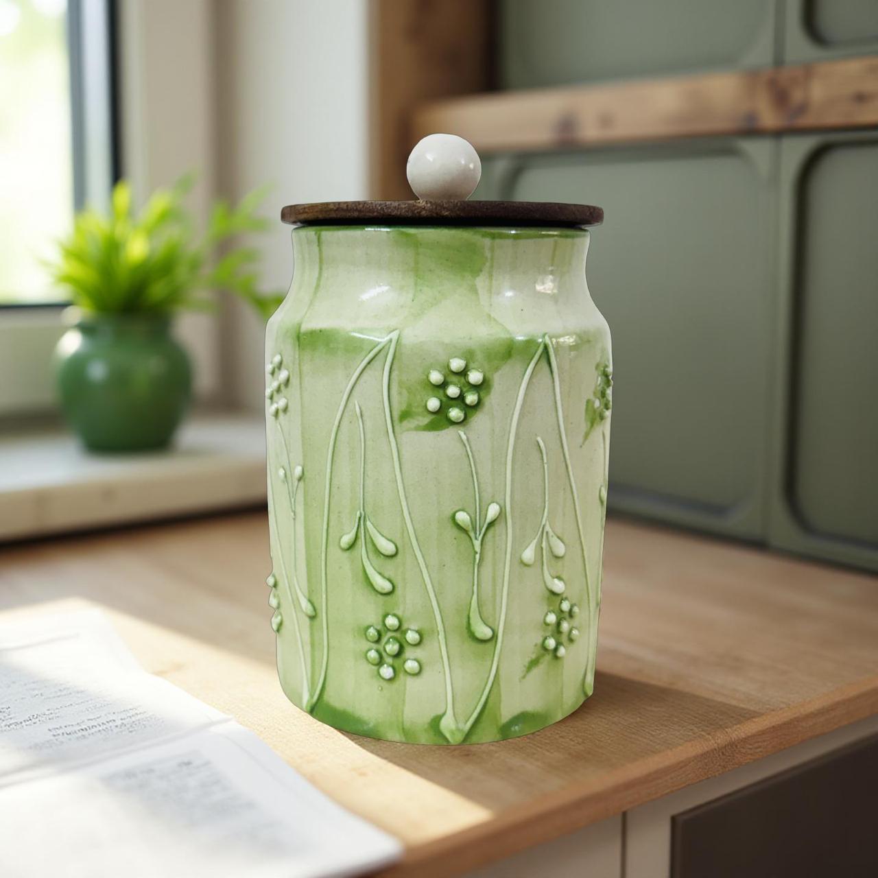 Decorative green ceramic jar with floral patterns on a wooden surface.