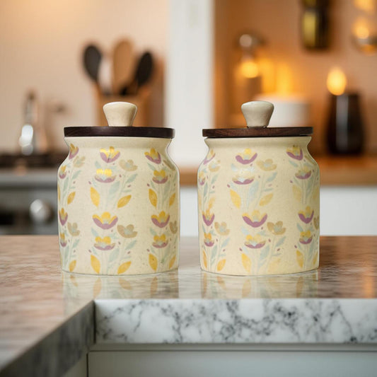 Two ceramic jars with floral patterns on a kitchen counter.