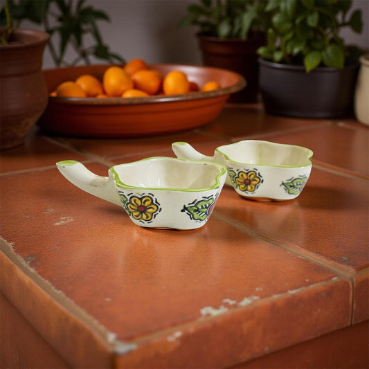 Two ceramic bowls with floral designs on a rustic wooden surface.