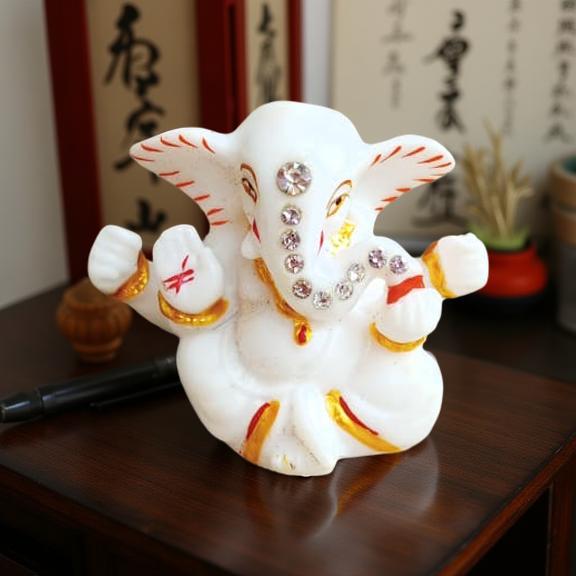Decorative ganesha idol figure on a wooden surface with blurred background