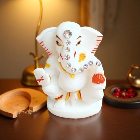 Decorative statue of a white elephant with embellishments on a wooden surface.