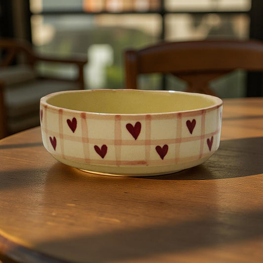 Ceramic bowl with heart patterns on a wooden table