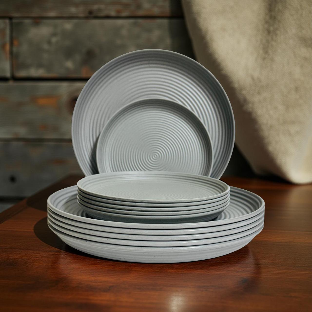 Set of gray melamine plates stacked on a wooden surface with a rustic background