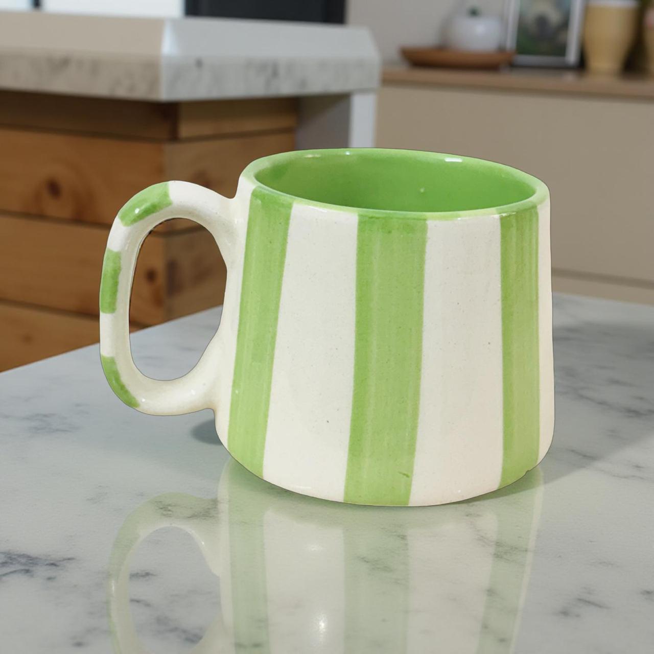 Green and white striped mug on a marble countertop