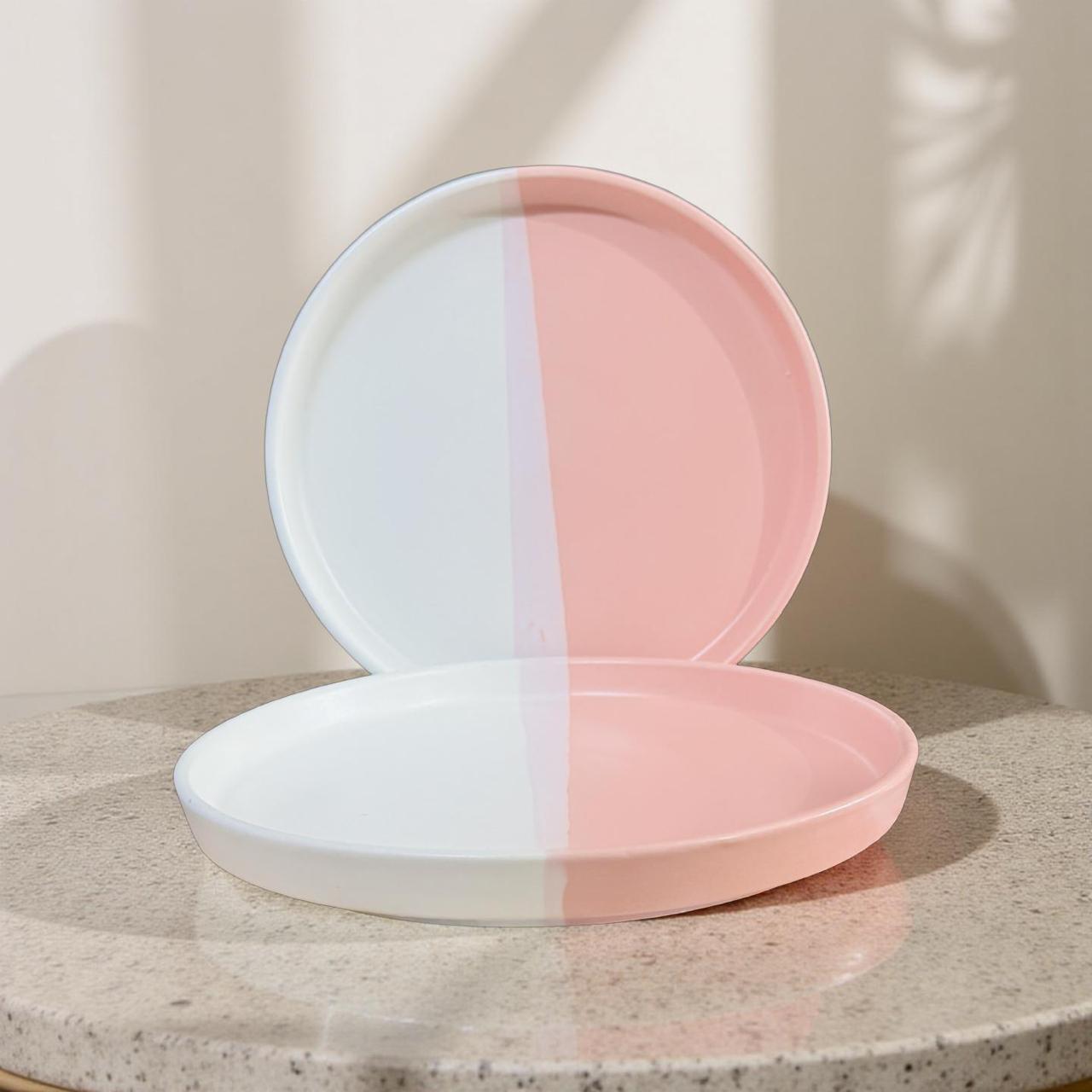 Two-tone pink and white compact mirror on a neutral background