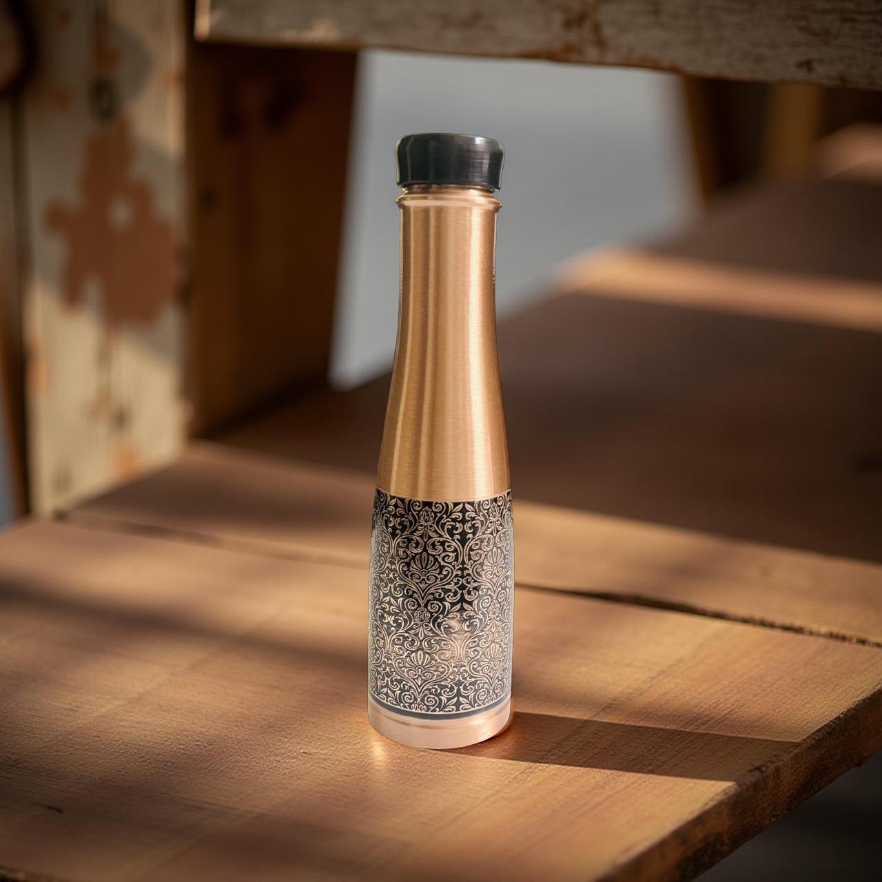 Decorative bottle with gold and black design on a wooden surface