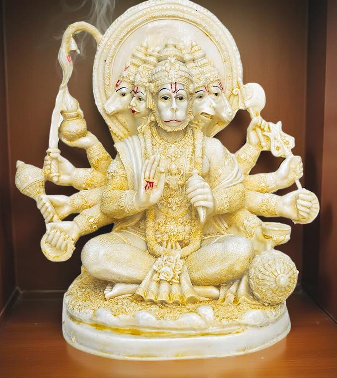 Statue of a multi-armed deity with intricate details on a brown background