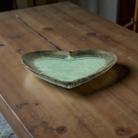 Green ceramic dish on a wooden surface