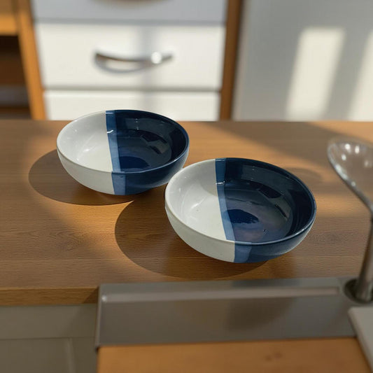 Two blue and white ceramic bowls on a wooden surface with a blurred kitchen background.