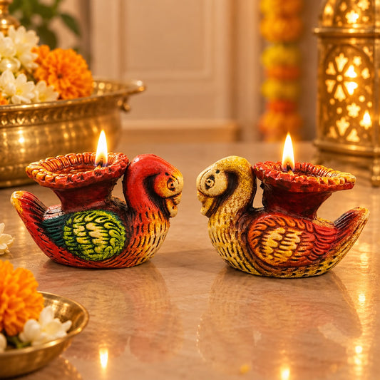 Colourful bird shaped diya set of two with lit lamps