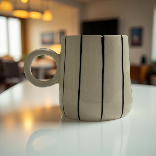 Striped ceramic mug on a table with a blurred indoor background