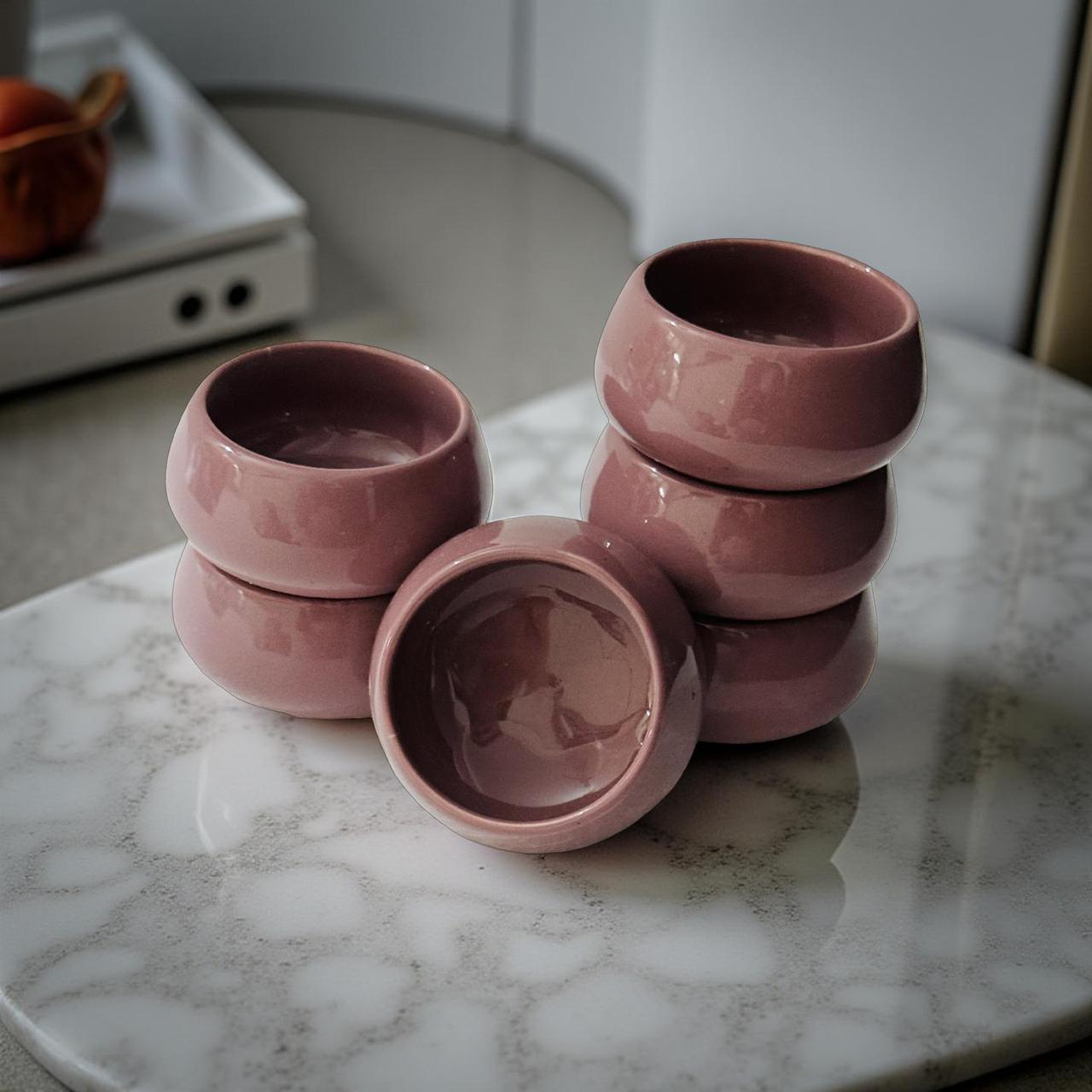 Stack of pink ceramic bowls on a marble surface