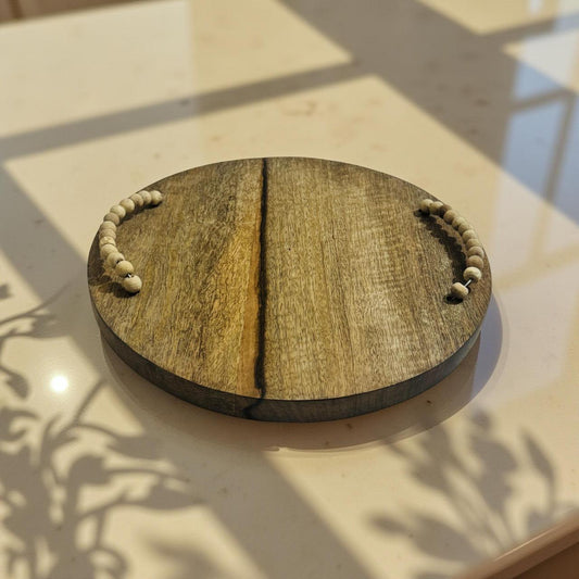 Wooden round tray with handles on a light surface