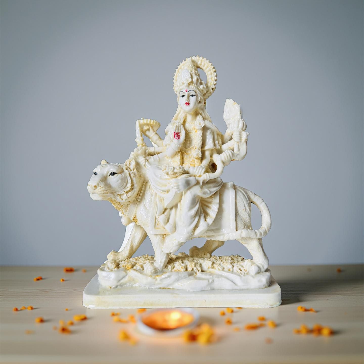 Statue of a deity riding a bull on a wooden surface with a gray background