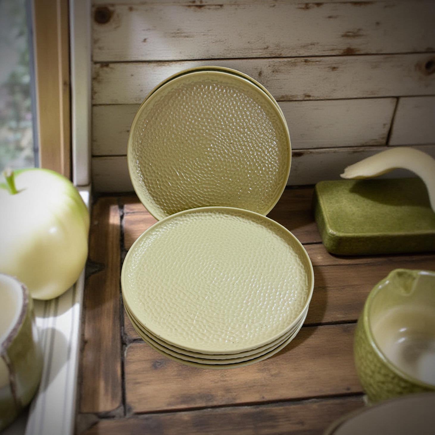 Stack of ivory textured plates on a wooden surface with a wooden wall in the background.