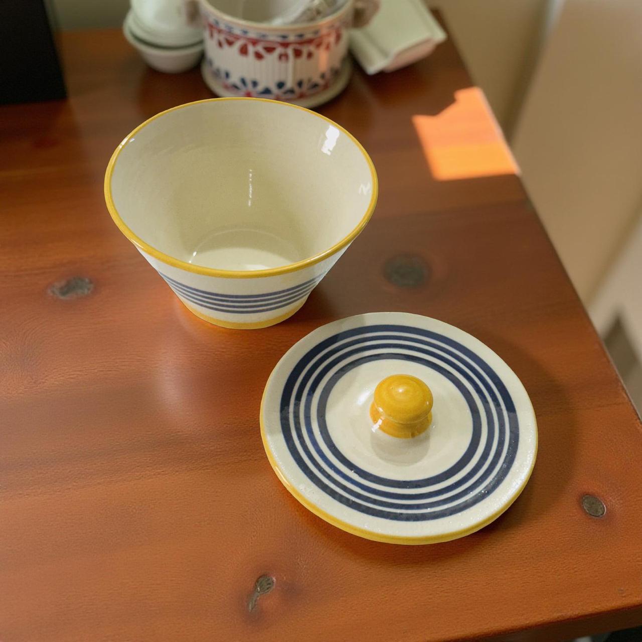Ceramic bowl and lid on a wooden surface