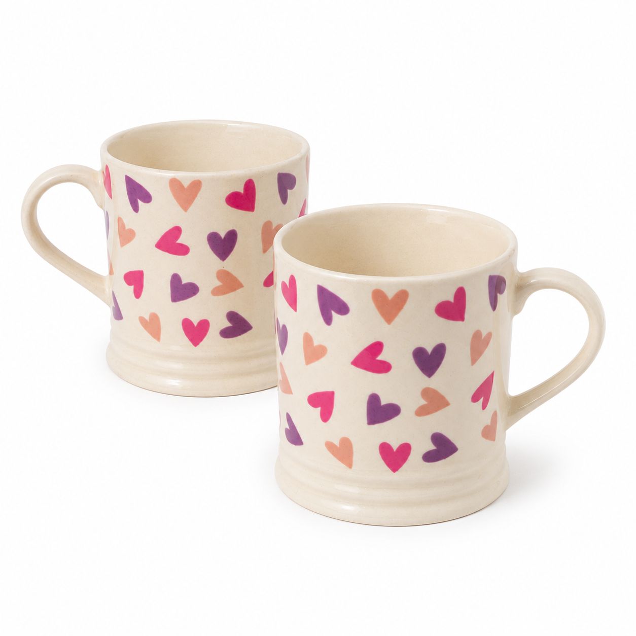 Two ceramic mugs with colorful heart patterns on a white background