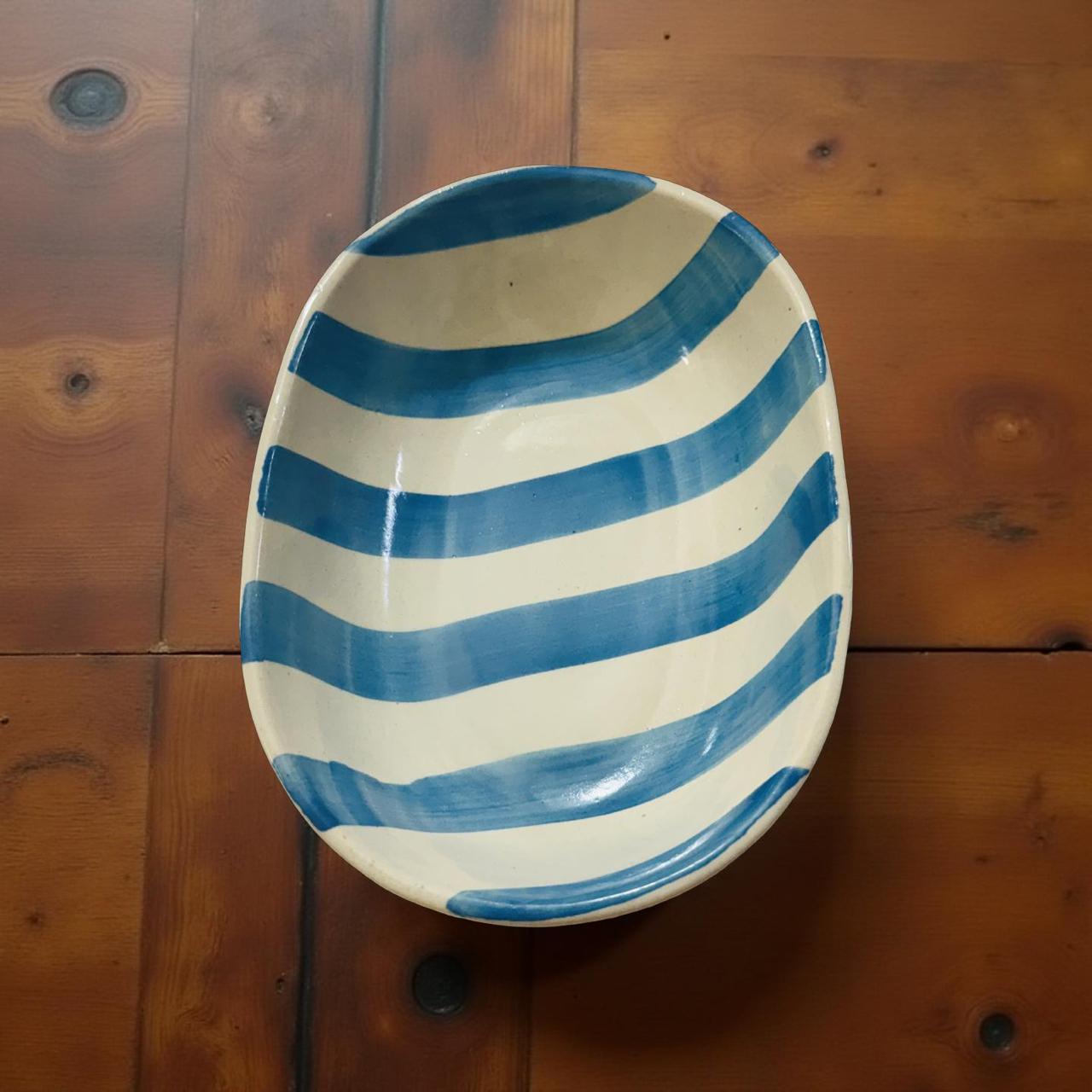 Ceramic plate with blue and white stripes on a wooden surface