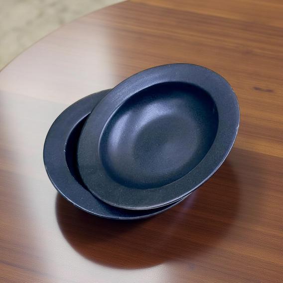 Two blue ceramic plates stacked on a wooden surface