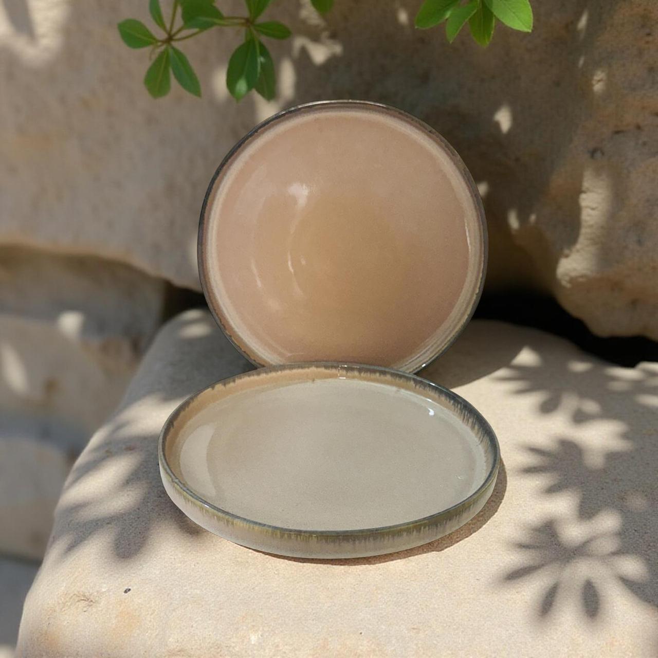 Two ceramic bowls on a stone surface with a natural background
