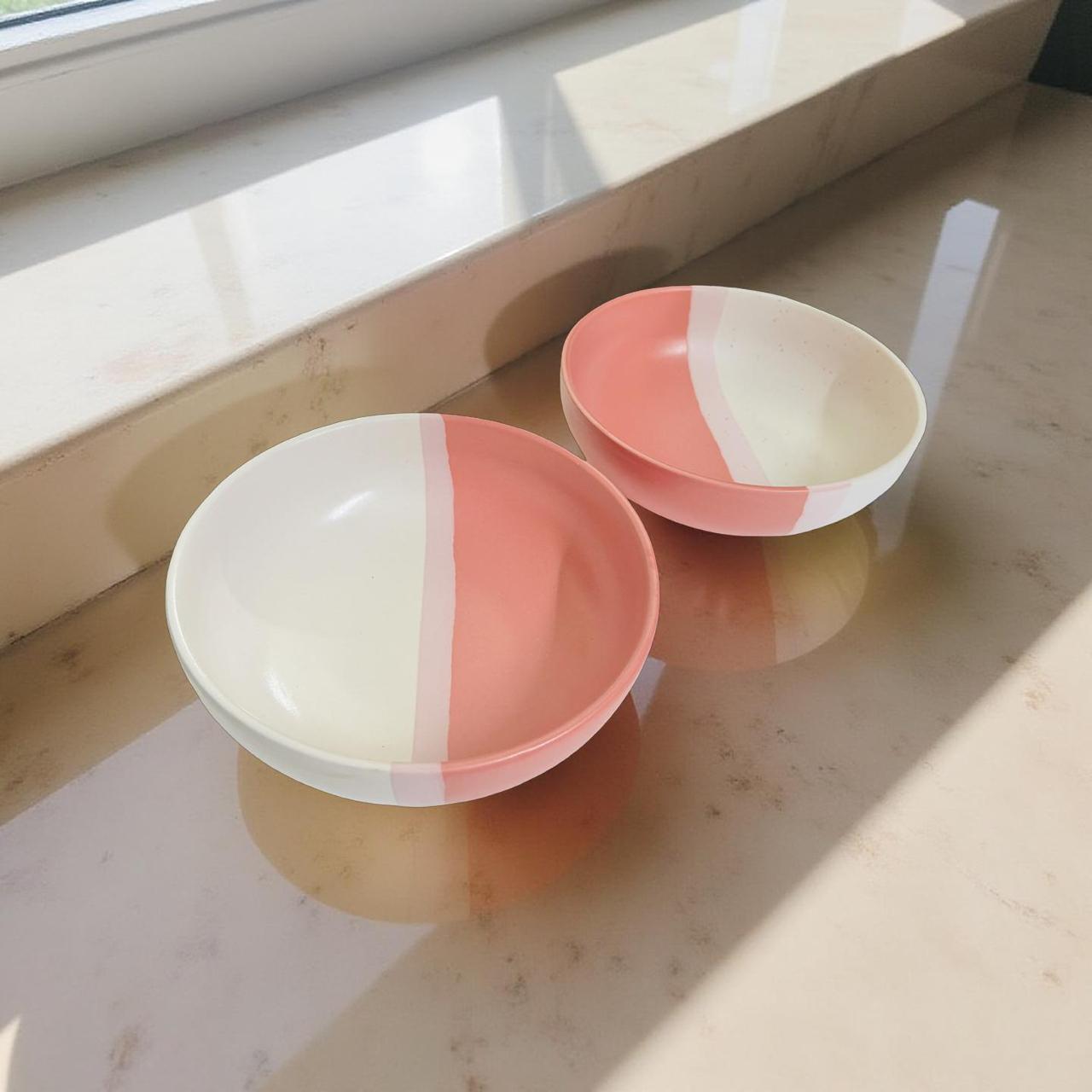 Two ceramic bowls with a two-tone design on a light surface.