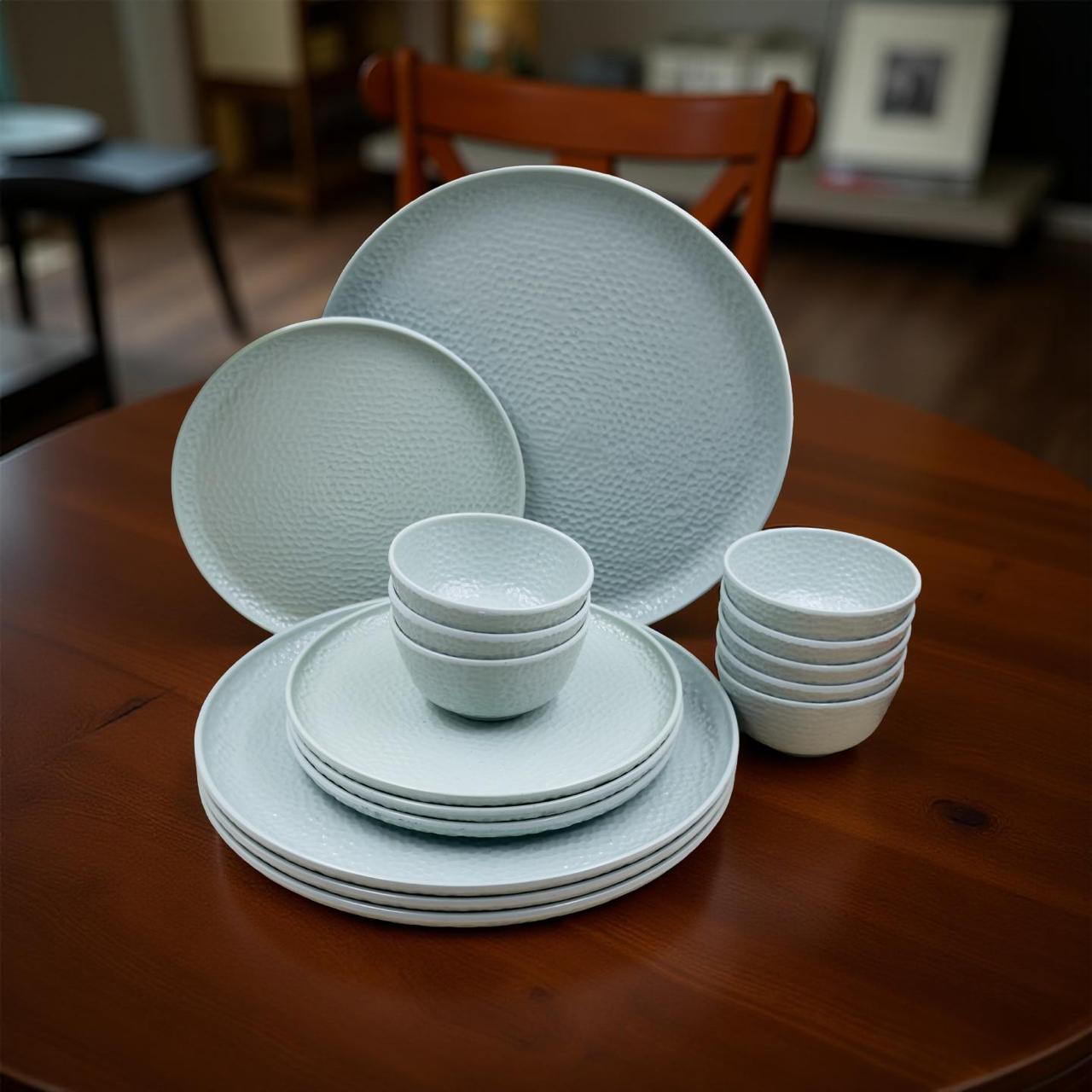 Set of light blue ceramic plates and bowls on a wooden table