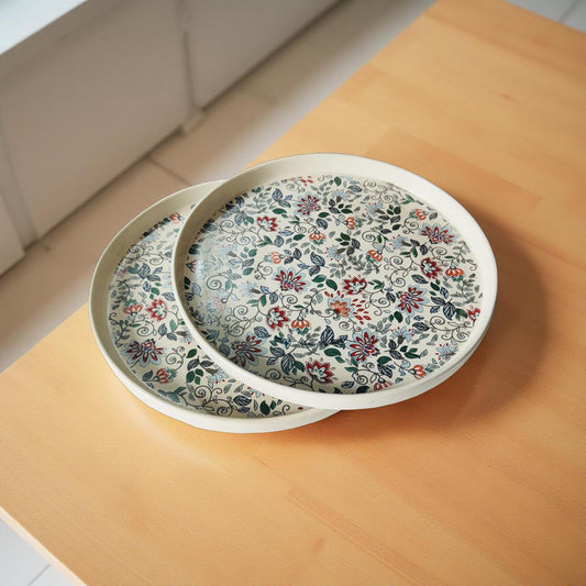 Two floral-patterned plates stacked on a wooden surface